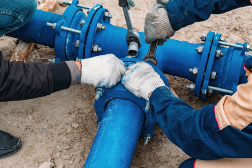 Workers,Installing,Water,Supply,Pipeline,System,,Close,Up